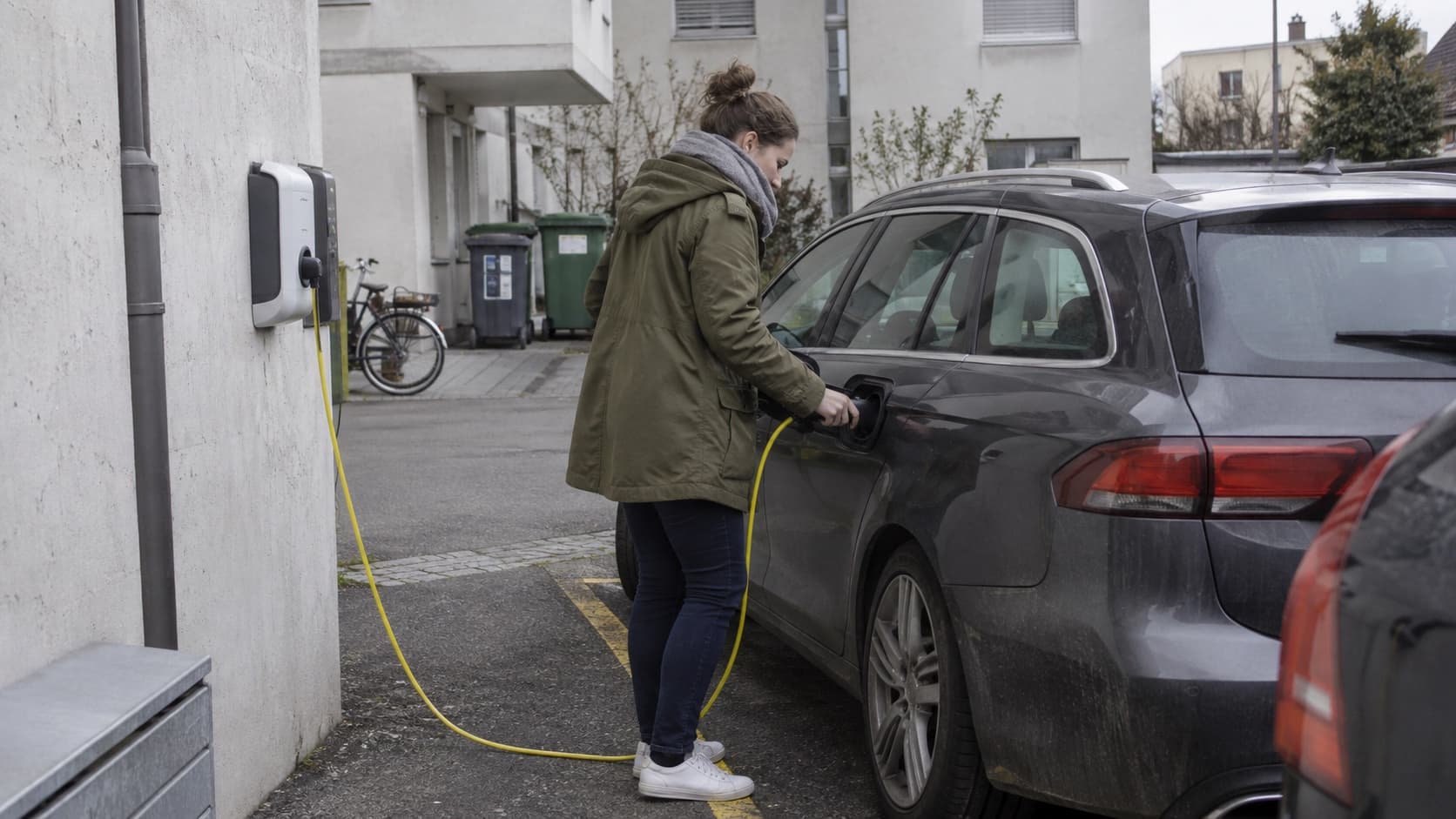 Symbolbild: Plug-in-Hybrid am Ladekabel vor einem Schweizer Wohnhaus